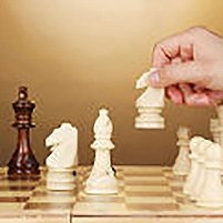 Chess board with chess pieces on brown background, © Africa Studio – Fotolia